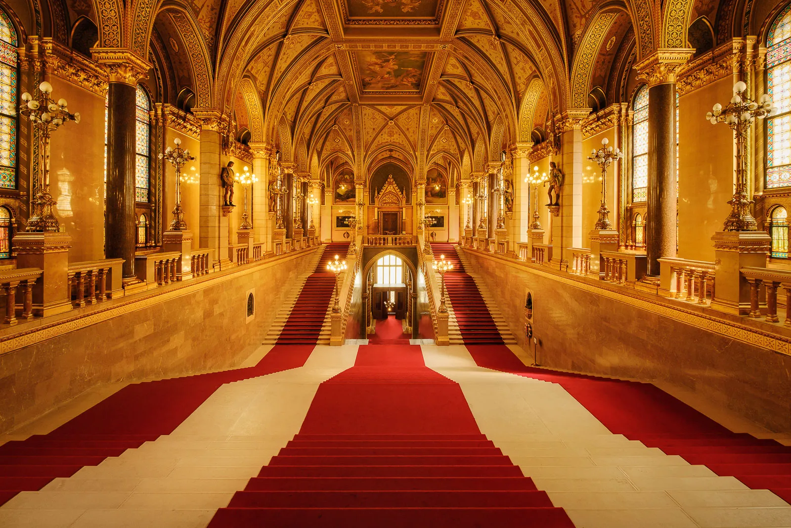 The main entrance to The Hungarian Parliament in Budapest. The interior features marble walls and gold coated decorations with statues and paintings of Hungarian history.